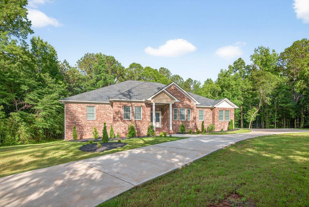 a front view of a house with a yard and trees