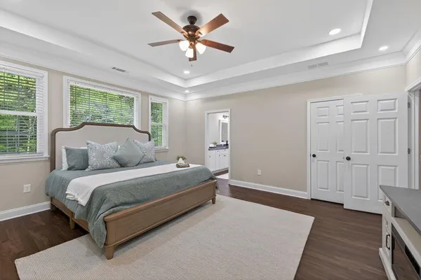 a spacious bedroom with a bed and a chandelier