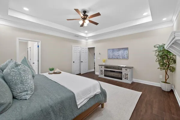 a spacious bedroom with a bed and a potted plant