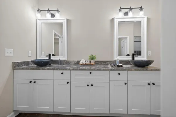 a bathroom with white cabinets and a sink