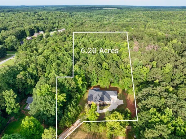 an aerial view of a residential houses with yard