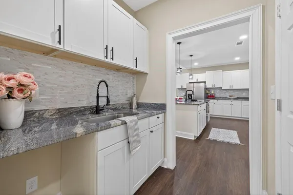 a kitchen with a sink cabinets and wooden floor