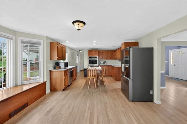 a kitchen with stainless steel appliances granite countertop a refrigerator stove microwave and wooden floor