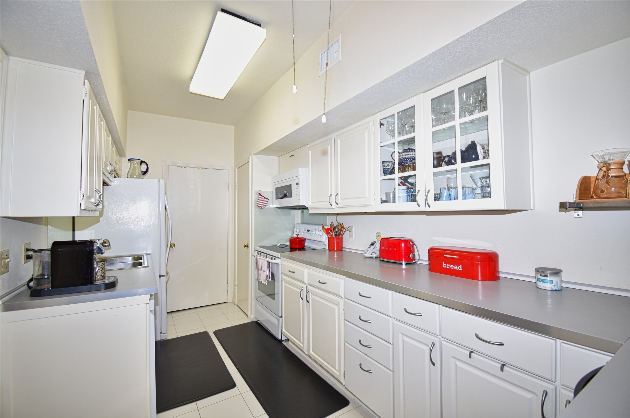 2425 Underwood Street, Unit 346 Houston, TX 77030 - Photo 18 of 30 a kitchen with cabinets and white appliances