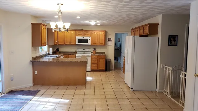 a kitchen with stainless steel appliances granite countertop a refrigerator a stove a sink and a microwave