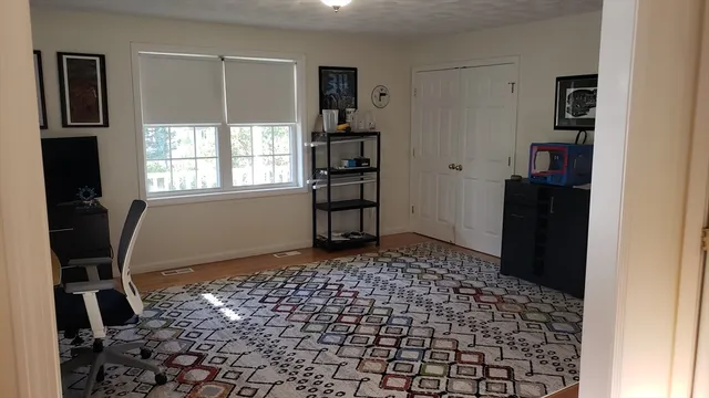 a view of a livingroom with wooden floor and a window