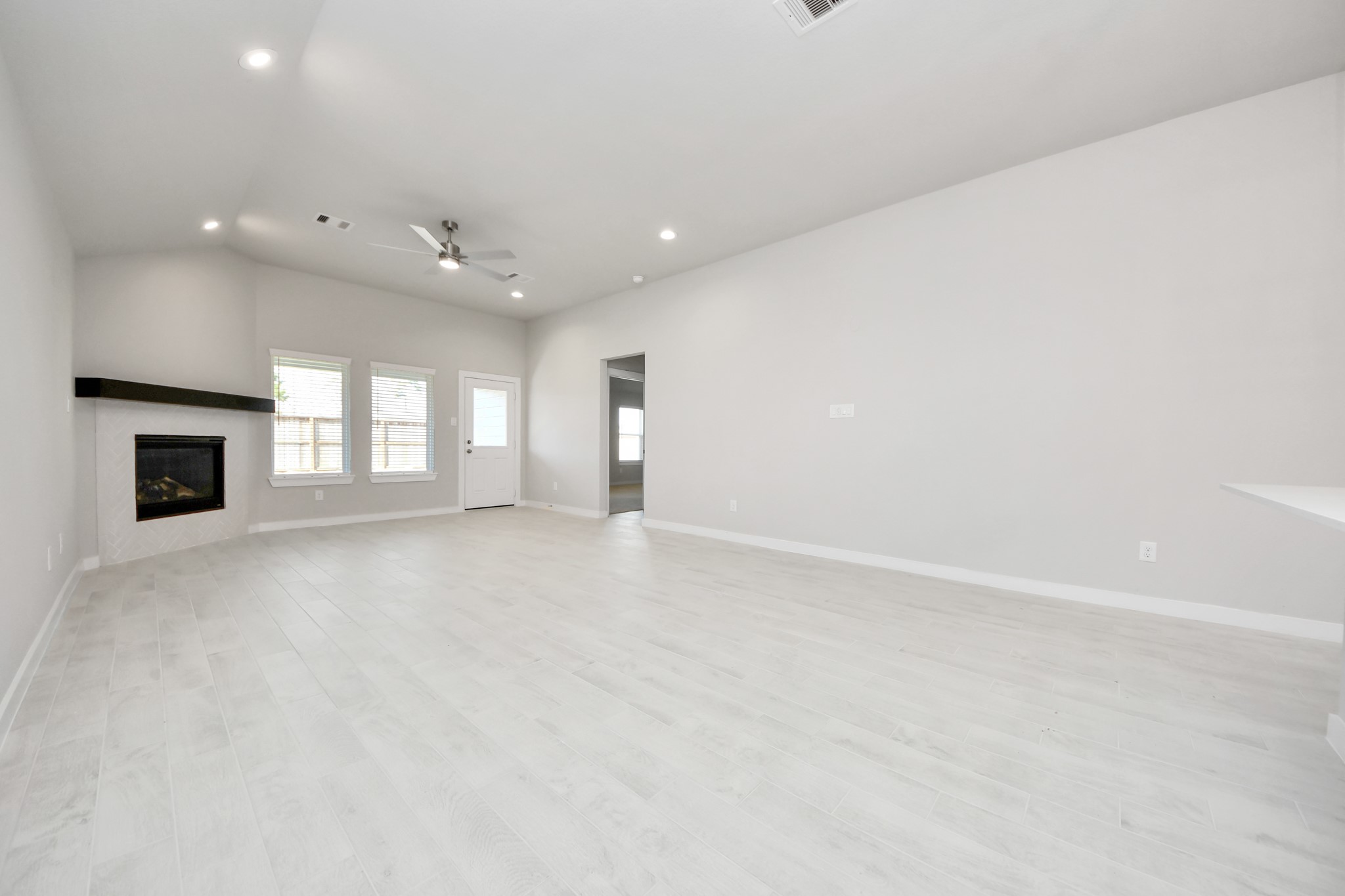 311 Ice Shr Trail Dayton, TX 77535 - Photo 17 of 35 Gather the family and guests together in your lovely living room! Featuring soaring high ceilings, recessed lighting, ceiling fan, custom paint, gorgeous floors, and large windows that provide plenty of natural lighting throughout the day. Sample photo of completed home with similar floor plan. Actual colors and selections may vary.