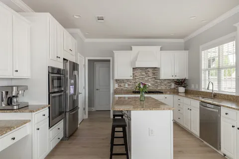 a kitchen with granite countertop a sink a counter space appliances and cabinets