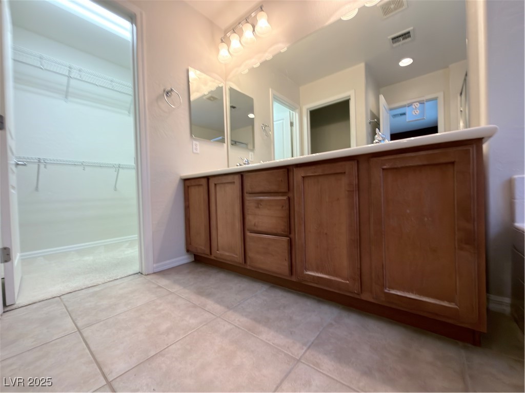 4650 Ranch House Road, Unit 95 North Las Vegas, NV 89031 - Photo 14 of 50 Bathroom with light tile patterned flooring, double vanity, and a spacious closet