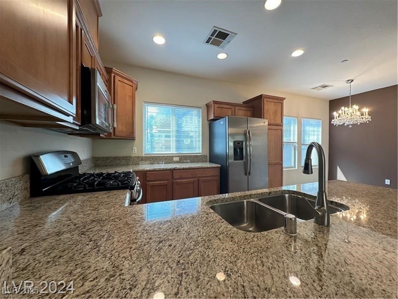 4650 Ranch House Road, Unit 95 North Las Vegas, NV 89031 - Photo 22 of 50 Kitchen featuring light stone countertops, stainless steel appliances, brown cabinets, pendant lighting, and recessed lighting