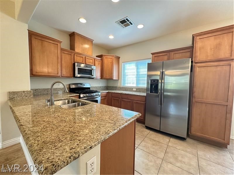 4650 Ranch House Road, Unit 95 North Las Vegas, NV 89031 - Photo 23 of 50 Kitchen featuring brown cabinets, a peninsula, stainless steel appliances, light stone counters, and recessed lighting