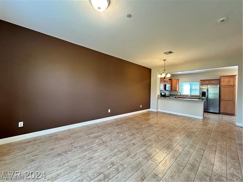 4650 Ranch House Road, Unit 95 North Las Vegas, NV 89031 - Photo 27 of 50 Unfurnished living room with a chandelier and light wood-style flooring