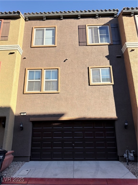 4650 Ranch House Road, Unit 95 North Las Vegas, NV 89031 - Photo 3 of 50 Rear view of property with stucco siding, an attached garage, and driveway