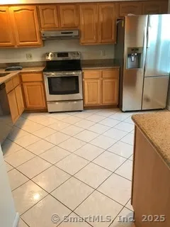 a kitchen with granite countertop white cabinets and white appliances