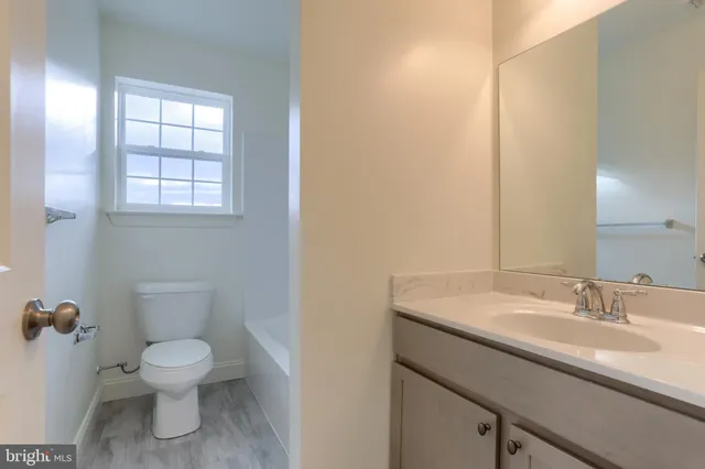 a bathroom with a toilet a sink and mirror