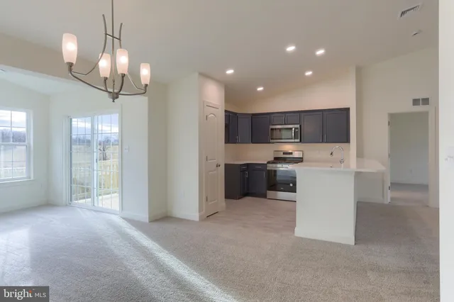 a view of a kitchen with a sink and dishwasher a refrigerator with wooden floor