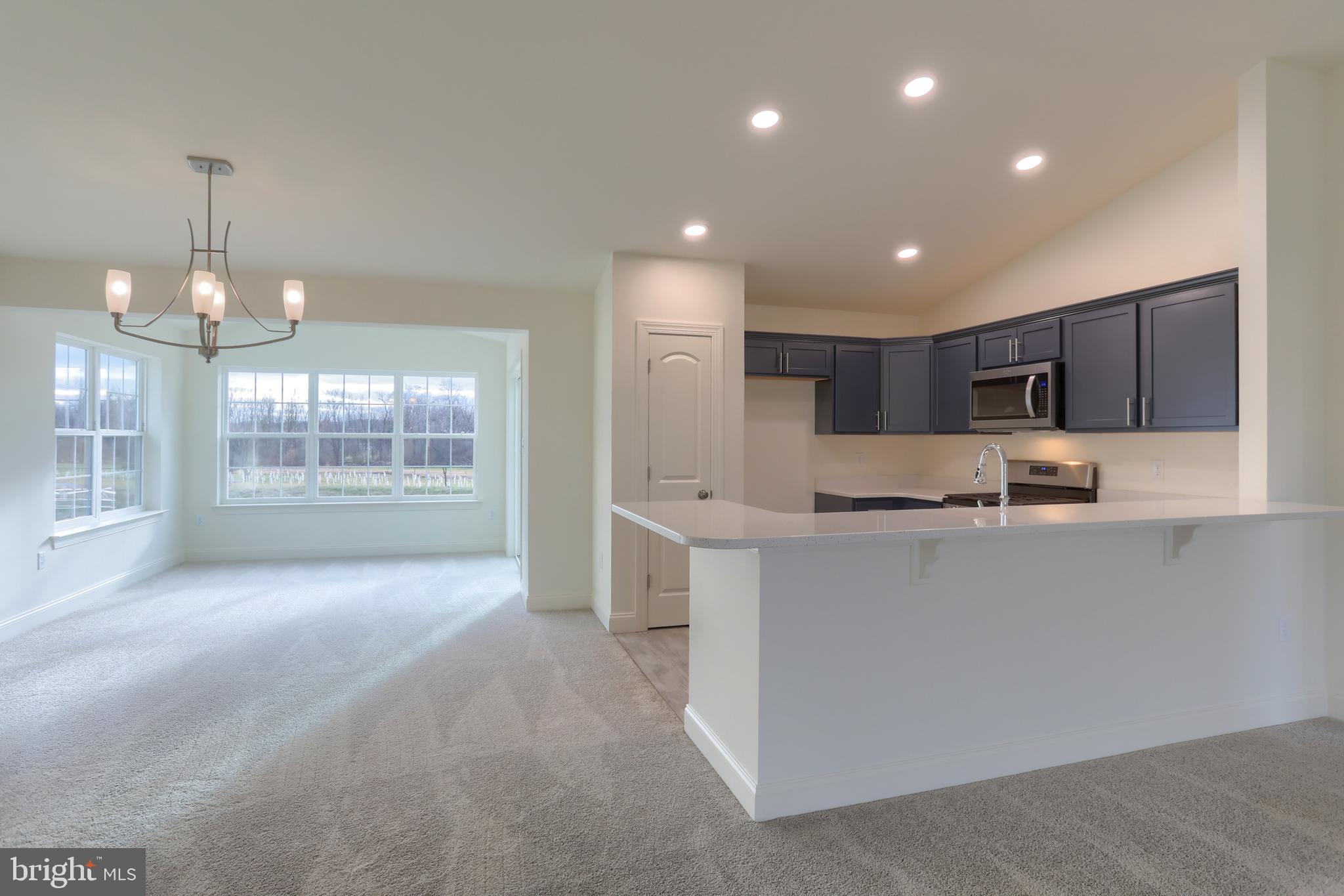 0 Lavender Lane Lebanon, PA 17042 - Photo 5 of 23 a large kitchen with kitchen island a sink a stove a refrigerator and a dining table with wooden floor