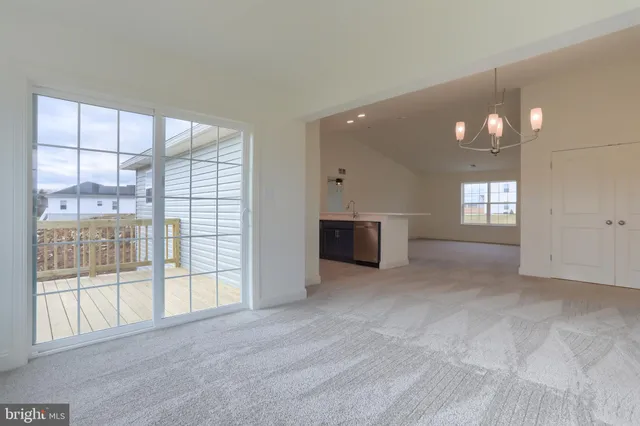 a view of an empty room with a window and fireplace