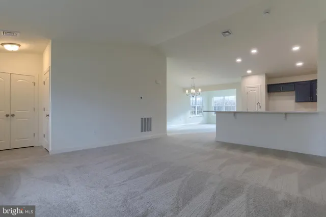 an empty room with kitchen and windows