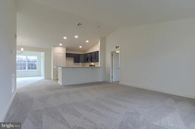 a view of an empty room with a kitchen