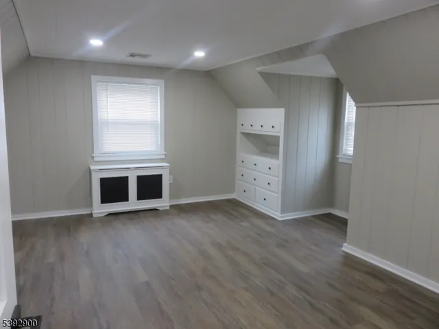 an empty room with wooden floor & windows