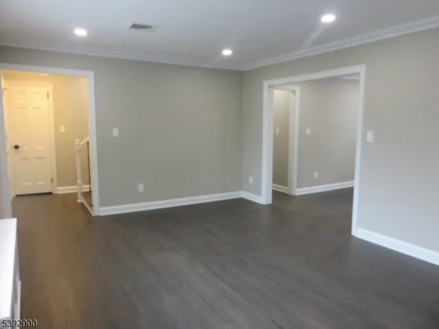 a living room with stainless steel appliances wooden floor and a fireplace