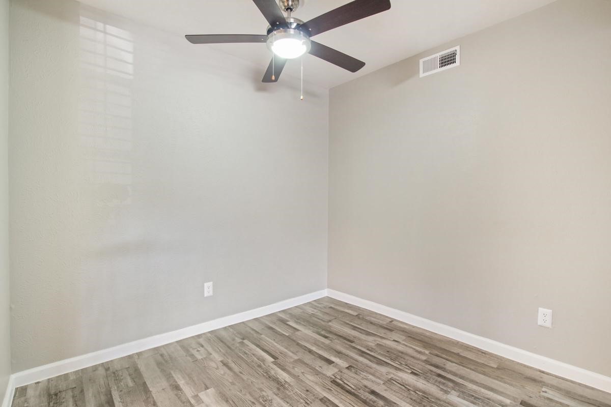 1212 Hampshire Lane, Unit 1322 Richardson, TX 75080 - Photo 7 of 50 an empty room with a ceiling fan and wooden floor