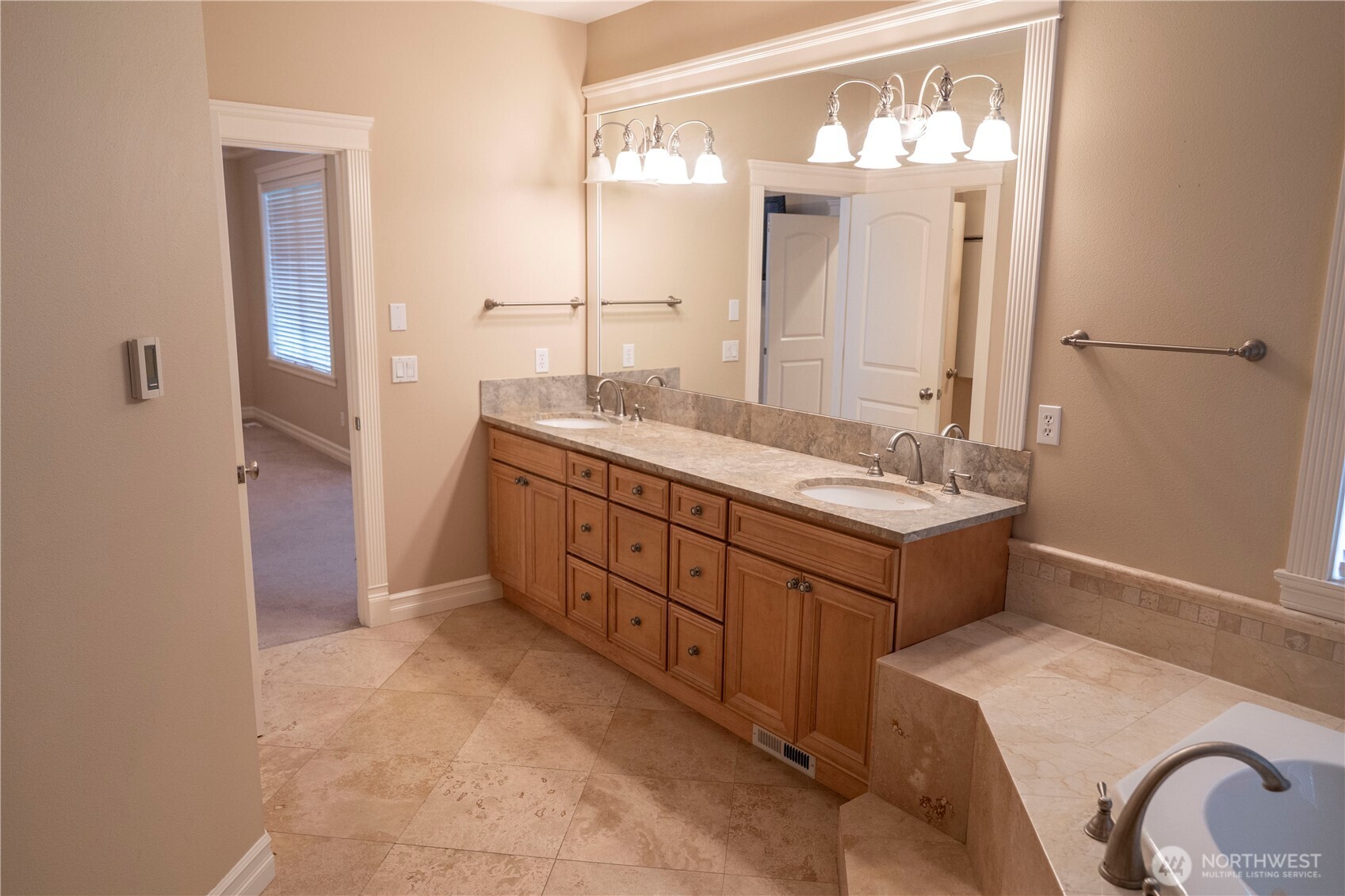 9701 148th Street Southeast Snohomish, WA 98296 - Photo 16 of 18 a bathroom with a double vanity sink a mirror and a bathtub