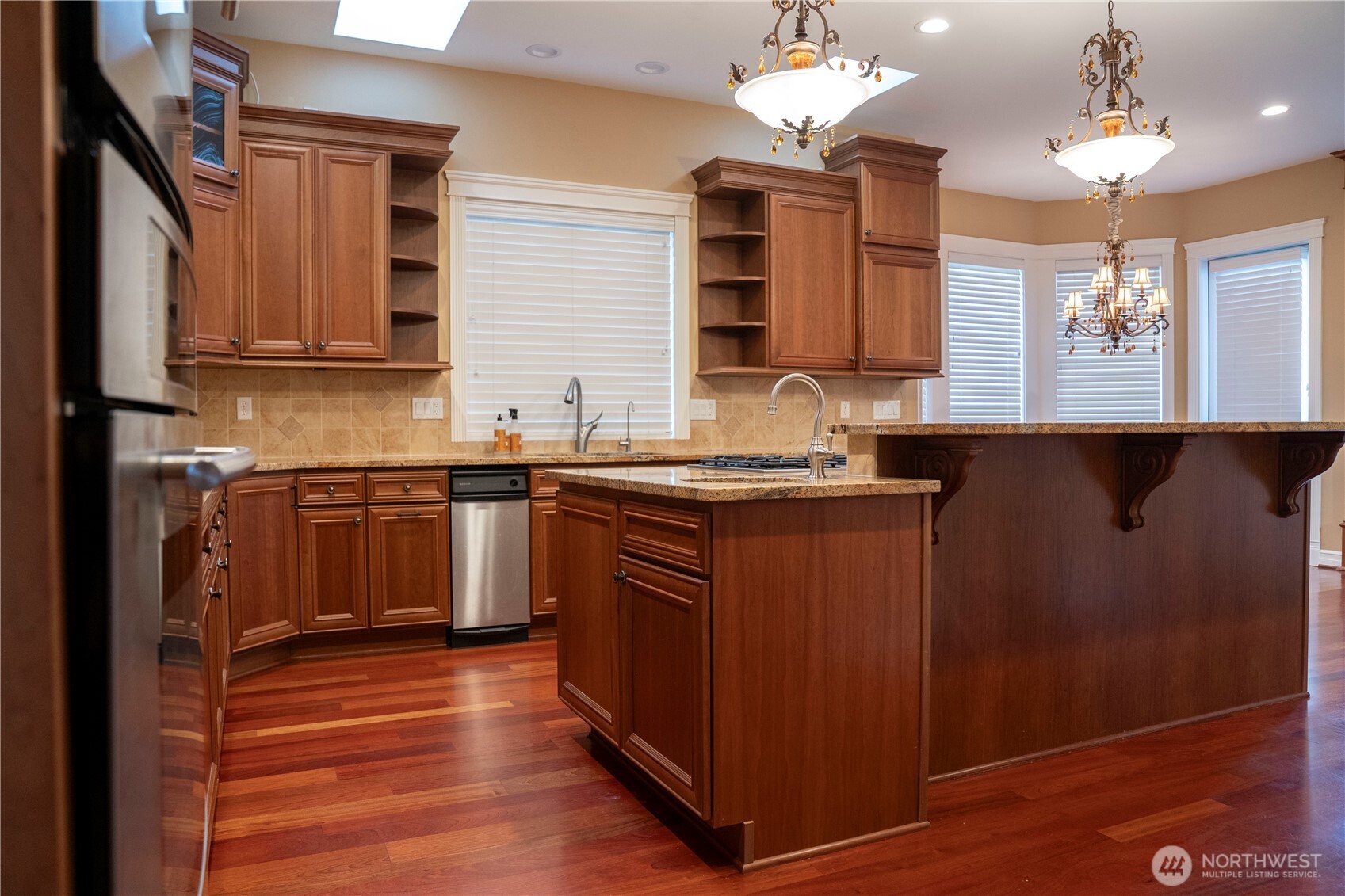 9701 148th Street Southeast Snohomish, WA 98296 - Photo 5 of 18 a kitchen with stainless steel appliances granite countertop a sink dishwasher a stove and a refrigerator with wooden floor