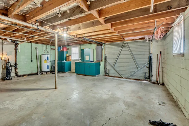 an empty room with windows and fireplace