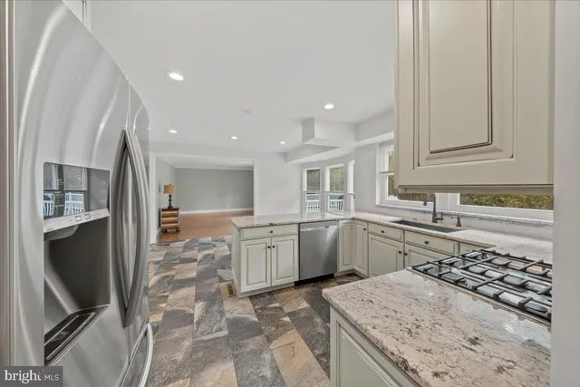 a bathroom with a granite countertop toilet a sink a mirror and a window