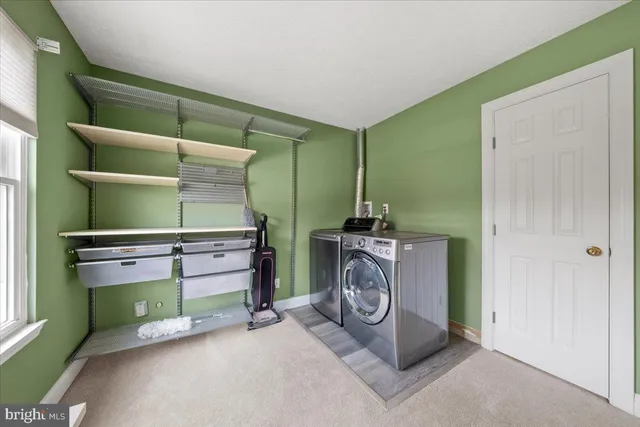 a kitchen with kitchen island a dining table chairs stainless steel appliances and cabinets
