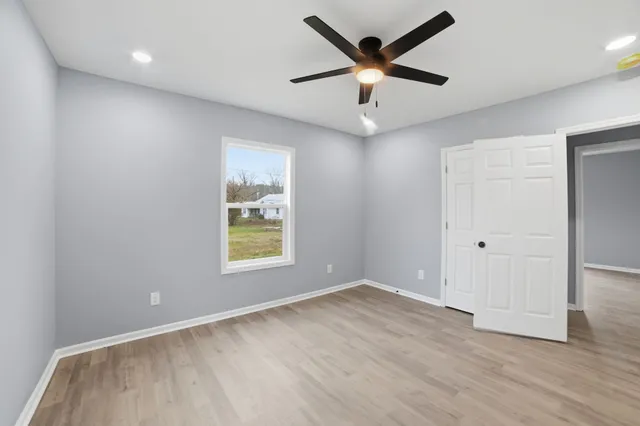 an empty room with wooden floor and windows