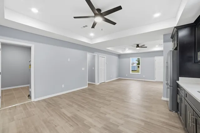 a view of an empty room with window and wooden floor