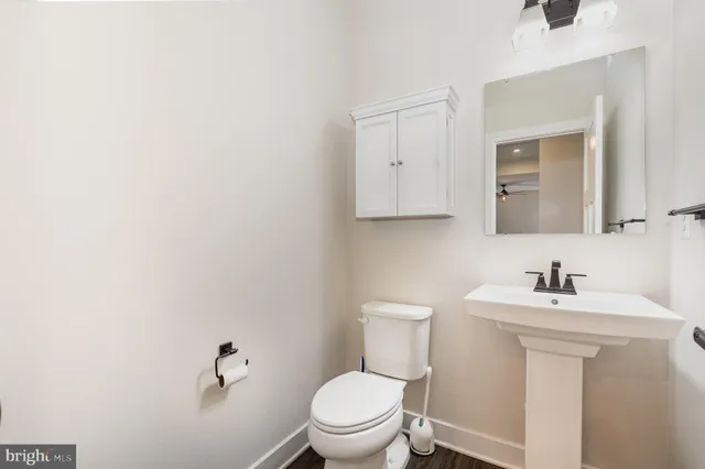a bathroom with a toilet sink and mirror