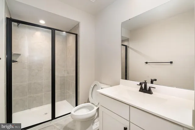 a bathroom with a sink a toilet a mirror and shower