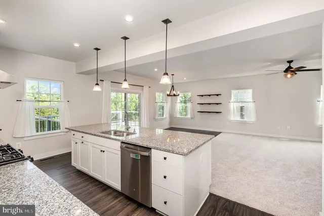 a kitchen with a sink stove and wooden floor