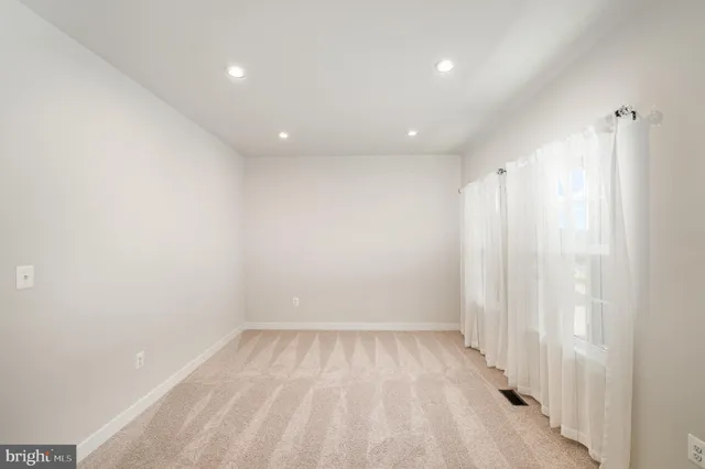 a view of a room with a wooden floor and window