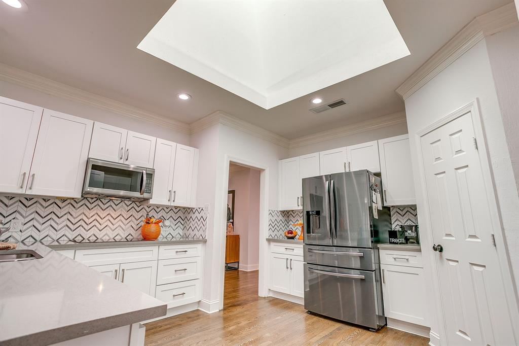 4304 Cobblers Lane Dallas, TX 75287 - Photo 6 of 31 a kitchen with stainless steel appliances a refrigerator stove and white cabinets