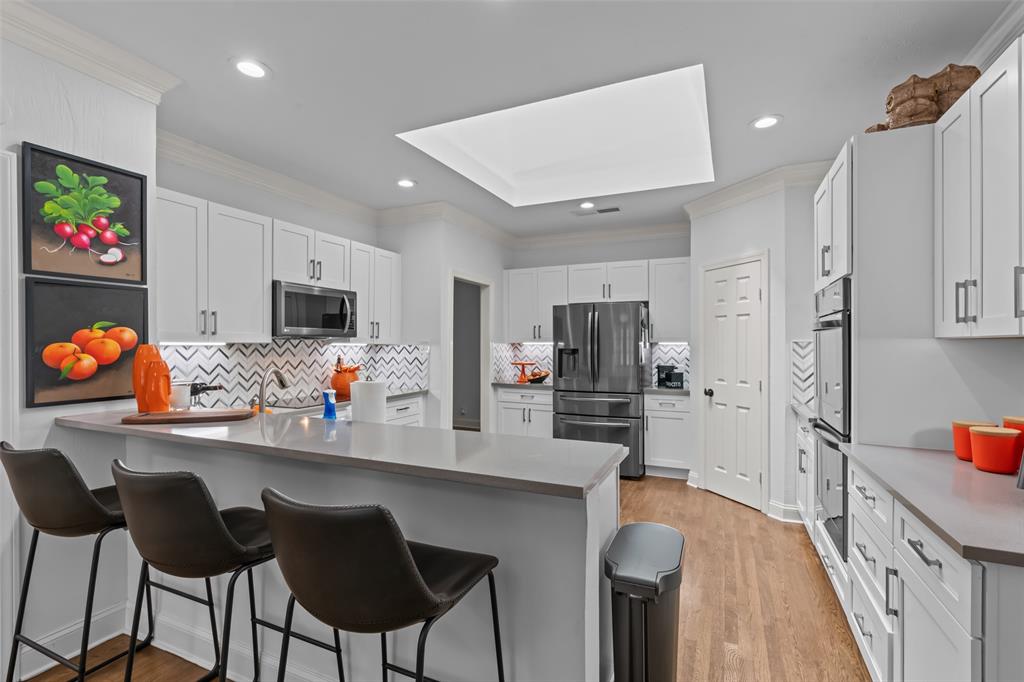 4304 Cobblers Lane Dallas, TX 75287 - Photo 7 of 31 a kitchen with stainless steel appliances a sink a stove a refrigerator cabinets and a dining table