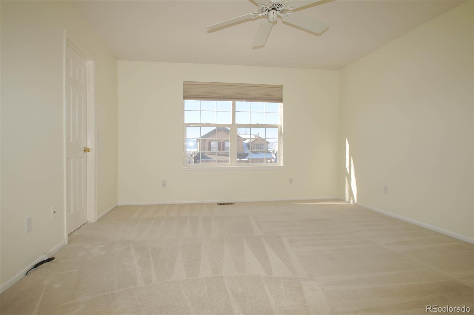 9638 Silverberry Circle Highlands Ranch, CO 80129 - Photo 20 of 27 an empty room with a window and a ceiling fan