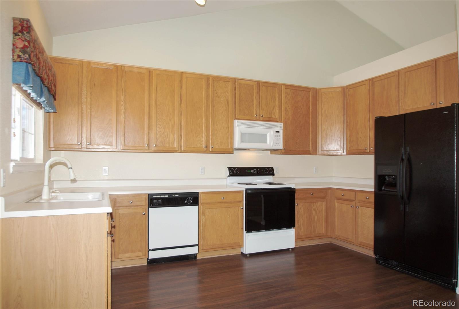 9638 Silverberry Circle Highlands Ranch, CO 80129 - Photo 3 of 27 a kitchen with granite countertop a refrigerator stove top oven and sink