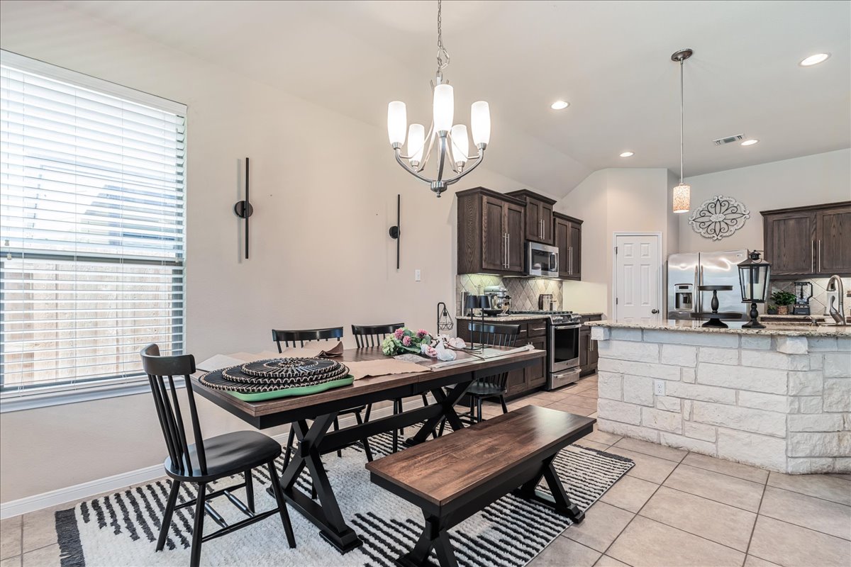 137 Navigator Drive Austin, TX 78717 - Photo 6 of 18 a view of a dining room with furniture a kitchen and chandelier
