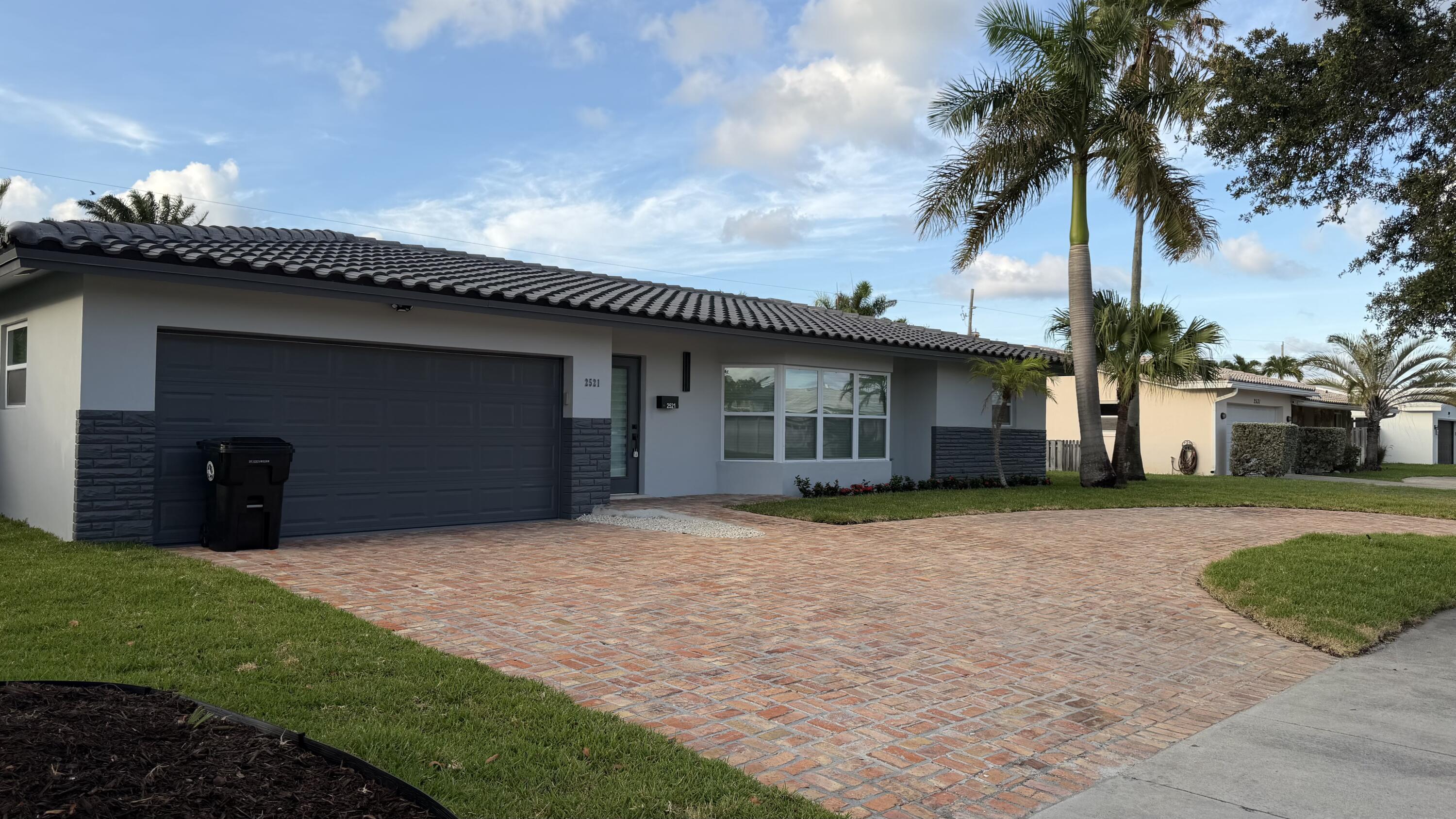 2521 Northeast 45th Street Lighthouse Point, FL 33064 - Photo 2 of 25 a front view of a house with a garden and yard