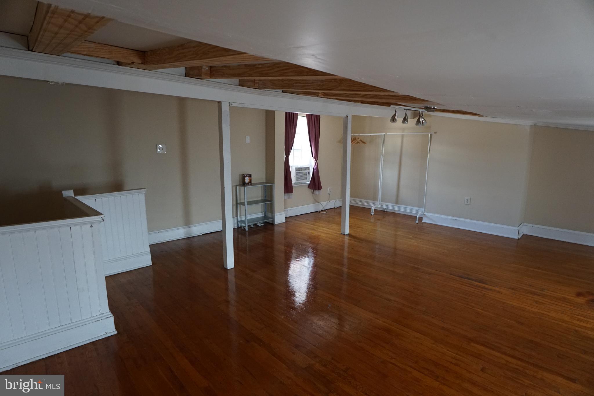 802 Cathedral Street, Unit 4 Baltimore, MD 21201 - Photo 13 of 15 a view of an empty room with wooden floor and a window