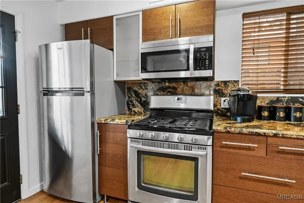 a kitchen with stainless steel appliances granite countertop a refrigerator stove and microwave
