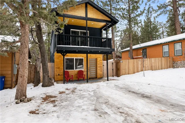 a front view of a house with a yard covered in snow