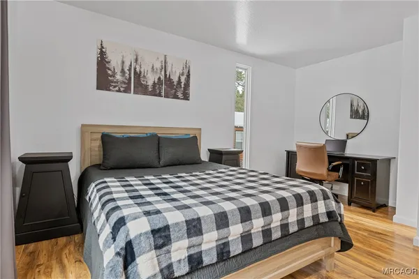 a bedroom with bed and wooden floor