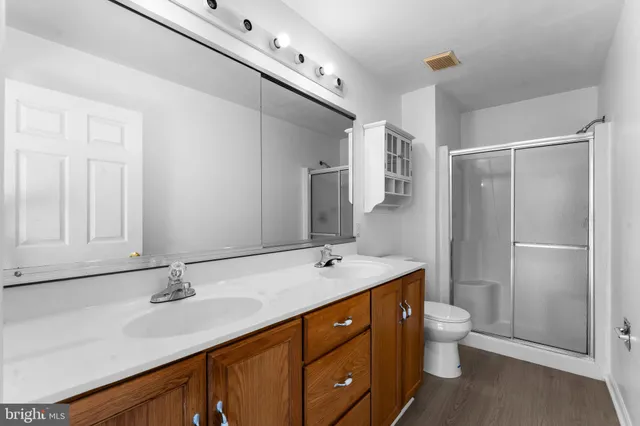 a bathroom with a sink double vanity granite toilet and a mirror