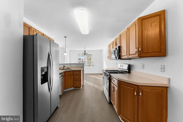 a kitchen with stainless steel appliances granite countertop a refrigerator a stove top oven a sink and dishwasher